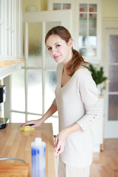 Молодая женщина делает работу по дому, убирает кухню — стоковое фото