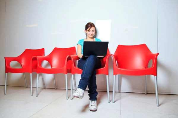 かなり若い女子学生大学キャンパスでのノート パソコンで — ストック写真