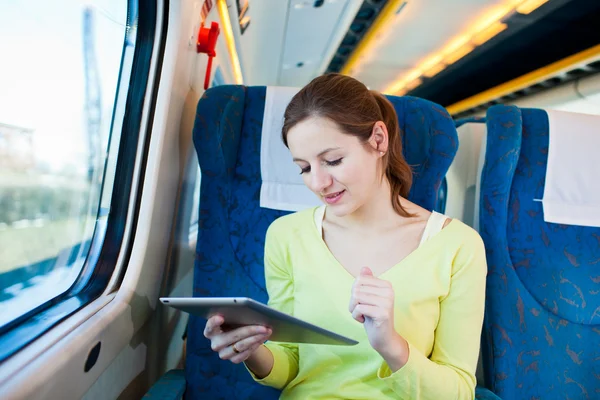 年轻女子乘火车旅行时使用她的平板电脑 — 图库照片