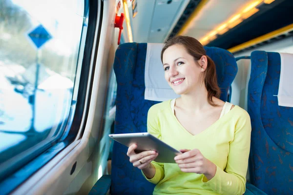 年轻女子乘火车旅行时使用她的平板电脑 — 图库照片