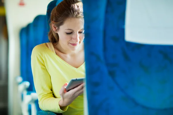 Jonge vrouw met behulp van haar tablet-pc terwijl het reizen met de trein — Stockfoto