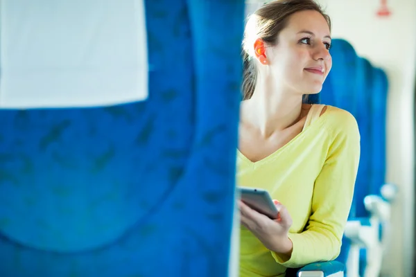 Mujer joven usando su tableta mientras viaja en tren —  Fotos de Stock