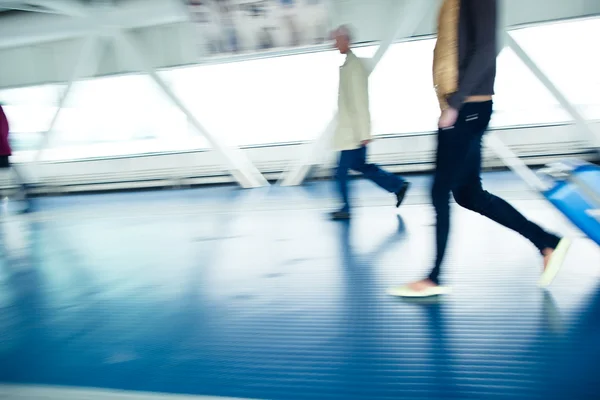 Con le loro valigie che camminano lungo un corridoio — Foto Stock
