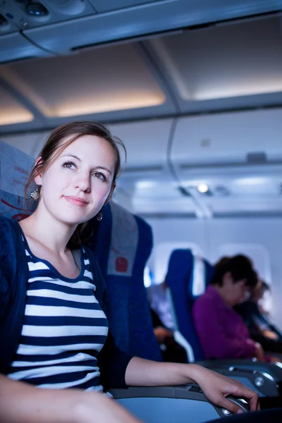 Pretty young female passenger on board of an aircraft — Stock Photo, Image