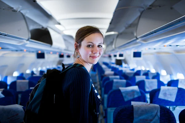 Hezká mladá žena cestujících na palubě letadla — Stock fotografie