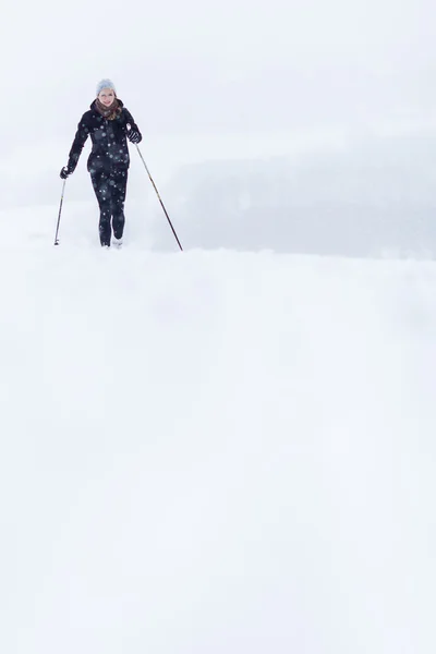 在白雪皑皑的冬日年轻女子越野滑雪 — 图库照片