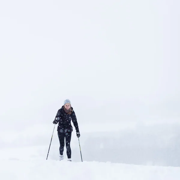 雪に覆われた冬の日の若い女性のクロスカントリー ・ スキー — ストック写真
