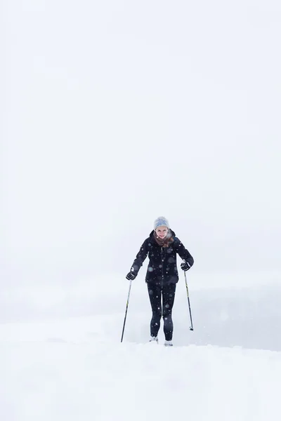 Молода жінка катається на лижах у сніжний зимовий день — стокове фото