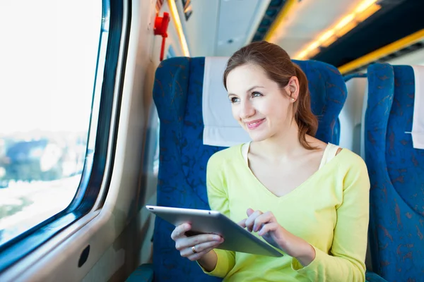 Young woman using her tablet computer while traveling by train Royalty Free Stock Images