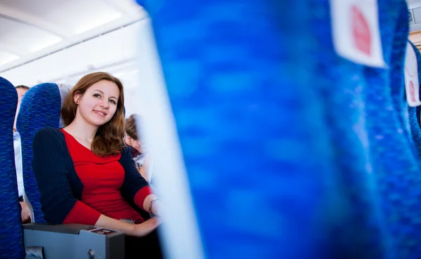 Pretty young female passenger on board of an aircraft — Stock Photo, Image