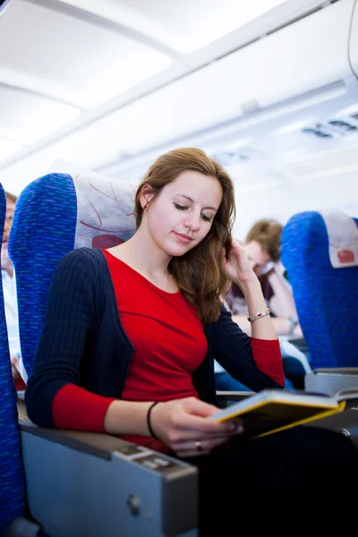 Pretty young female passenger on board of an aircraft — Stock Photo, Image