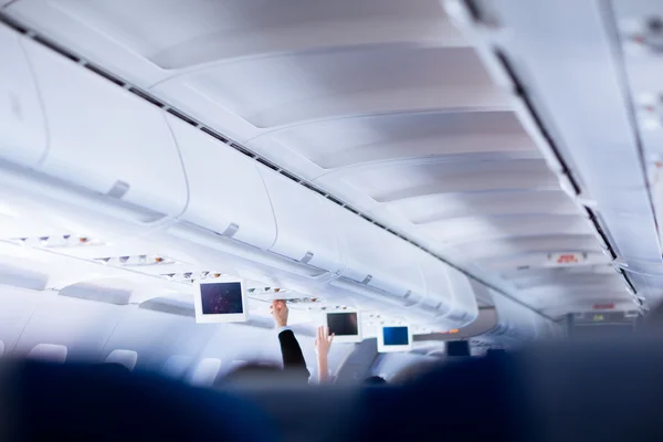 Passageiro ajustando o ar condicionado acima de seu assento — Fotografia de Stock