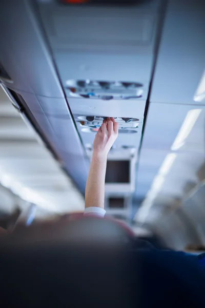 Pasajero ajustando aire acondicionado por encima de su asiento — Foto de Stock