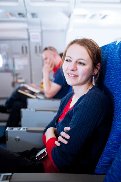 Csinos, fiatal női utas a fedélzeten egy repülőgép — Stock Fotó