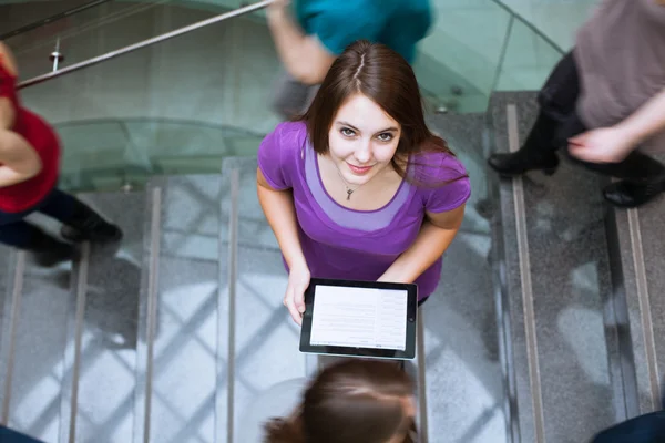 Hübsche junge Studentin auf dem Campus, einen Tablet-Computer in der Hand wh — Stockfoto