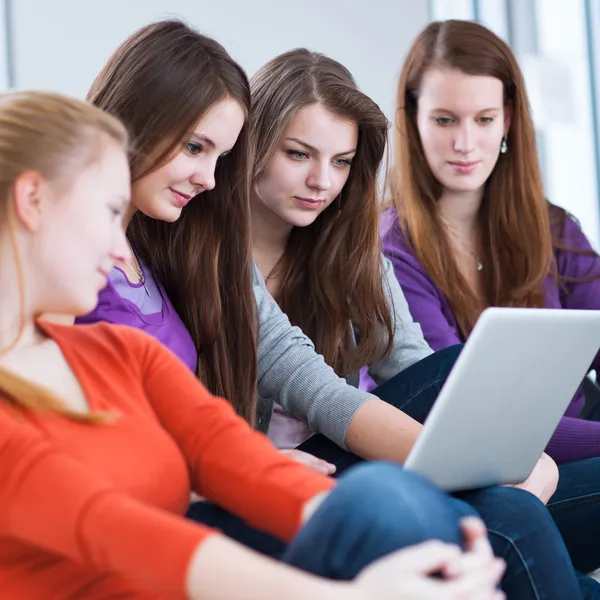 Quatre étudiantes utilisant un ordinateur portable — Photo