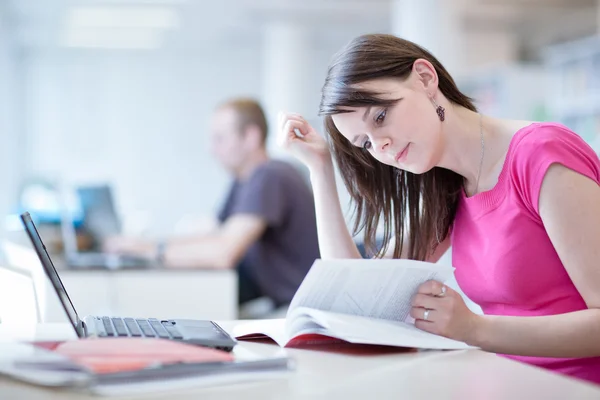 Pretty female student in the library Stock Image