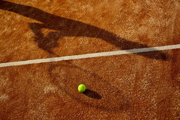 Sombra de um jogador de tênis em ação em um campo de tênis — Fotografia de Stock