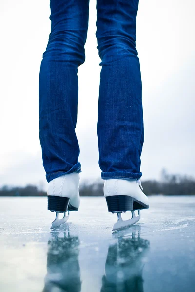 Mujer joven patinaje sobre hielo al aire libre en un estanque — Foto de Stock