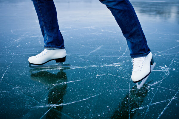 Молодая женщина катается на коньках на пруду
