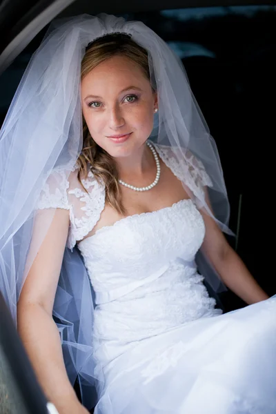 Retrato de uma bela jovem noiva esperando no carro — Fotografia de Stock
