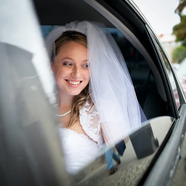 Porträt einer schönen jungen Braut, die im Auto wartet — Stockfoto