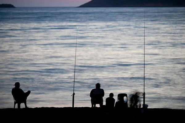 Sea/Ocean fishing - fishermen sitting by the sea/ocean — Stock Photo, Image