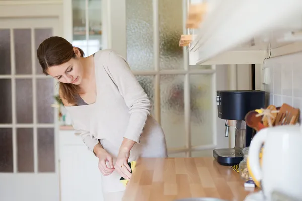 Молода жінка використовує посудомийну машину — стокове фото