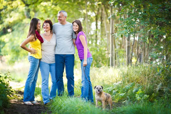 Семейный портрет - Семья из четырех человек с симпатичной собакой на открытом воздухе — стоковое фото