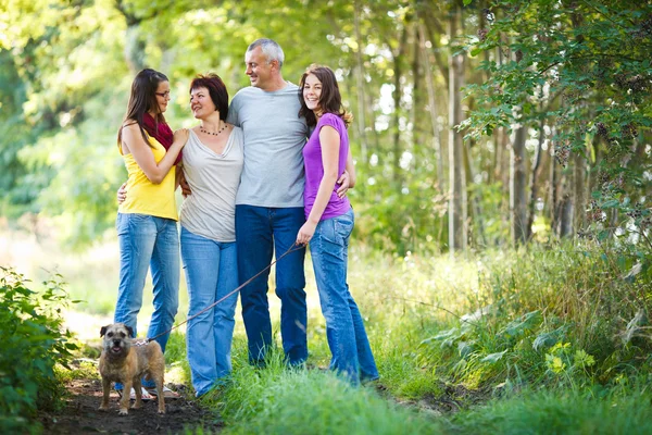 Retrato familiar - Familia de cuatro con un lindo perro al aire libre — Foto de Stock