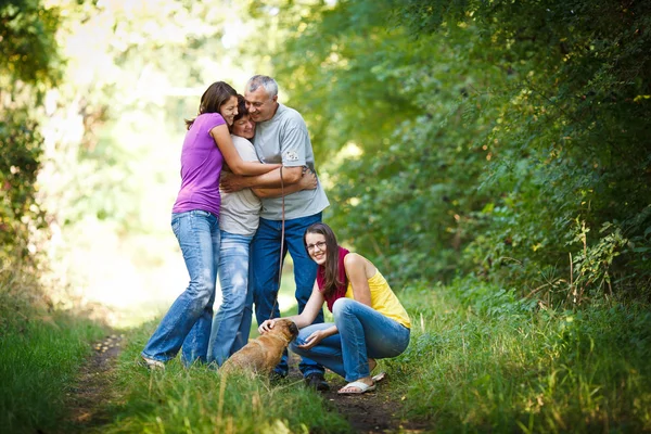 Rodinný portrét - rodiny čtyř s roztomilý pes venku — Stock fotografie