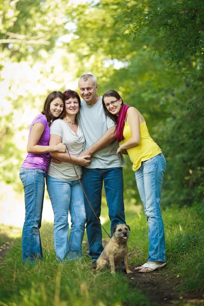 Ritratto di famiglia - Famiglia di quattro persone con un cane carino all'aperto — Foto Stock