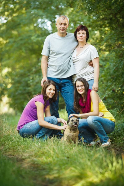 Family portrait - Family of four with a cute dog outdoors — Stock Photo, Image