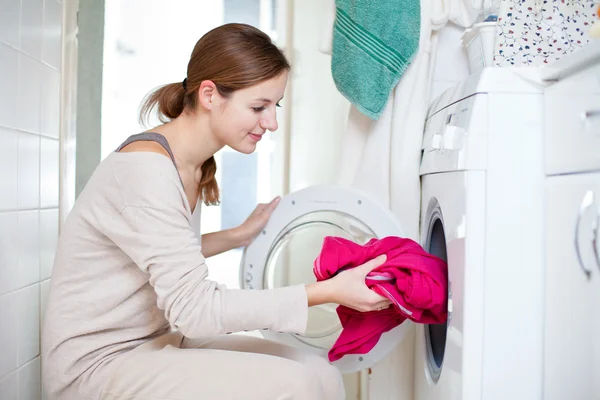 家务：年轻女子洗衣服 免版税图库图片