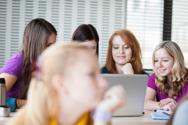 Four female college students working on their homework/having a clipart