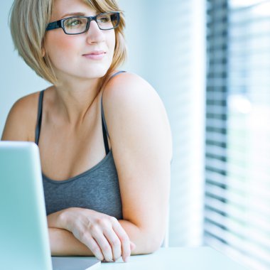 Portret van een jonge vrouw pensively kijken uit het raam