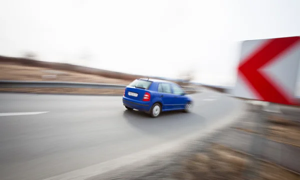 Conceito de tráfego: carro dirigindo rápido através de uma curva acentuada — Fotografia de Stock