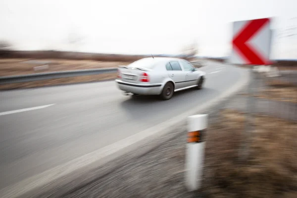 Traffic concept: car driving fast through a sharp turn — Stock Photo, Image