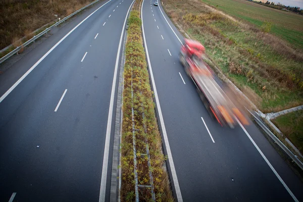 Tráfico por carretera - camión borroso en movimiento en una carretera / autopista — Foto de Stock
