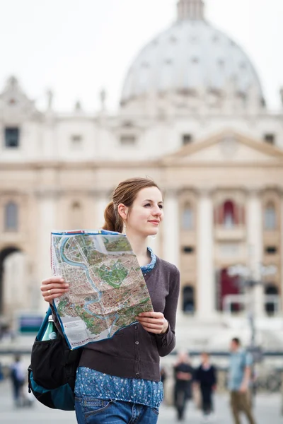 Pretty young female tourist studying a map at St. Peter's square — Stock Photo, Image