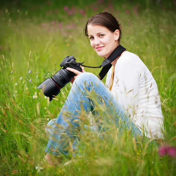 Mujer bastante joven con una cámara réflex digital al aire libre, tomando fotos — Foto de Stock