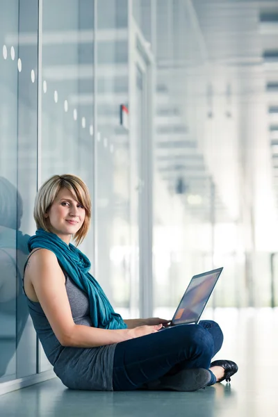 Mooie jonge vrouwelijke student met een laptopcomputer — Stockfoto