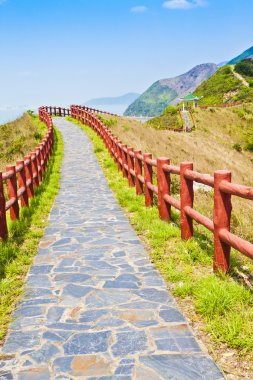 Hiking path and pavillion in mountain ridges clipart