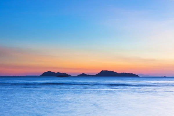 Острів на заході сонця над океаном — стокове фото