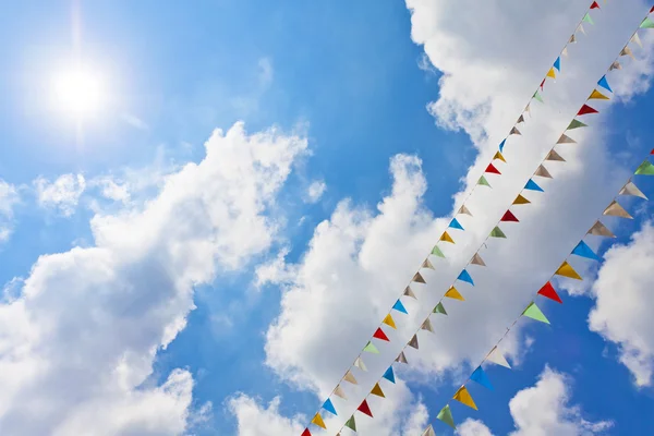 Ciel bleu avec des drapeaux de fête multicolores suspendus — Photo