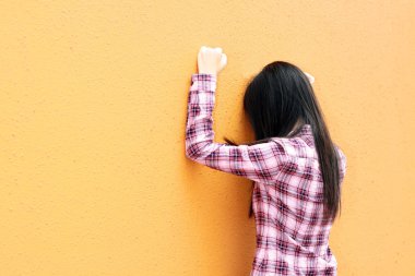 Asian woman very sad and facing the wall clipart