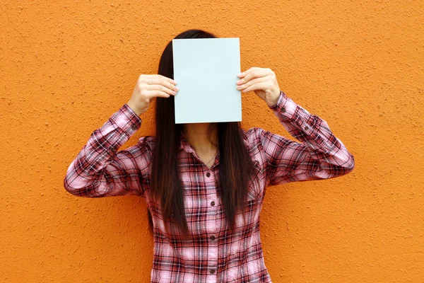Asiatin benutzt Buch, um Gesicht zu verhüllen — Stockfoto