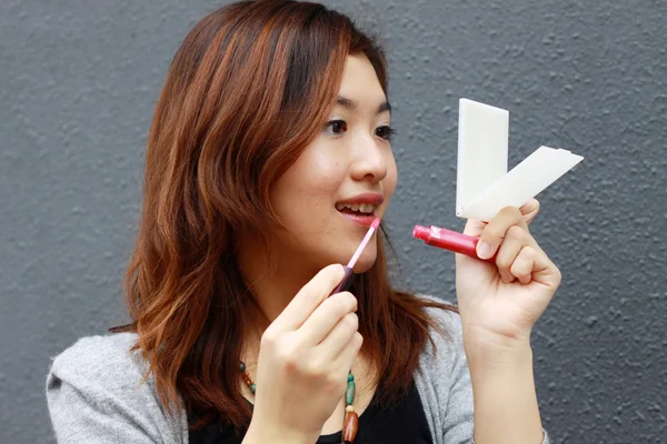 Азиатка делает макияж — стоковое фото