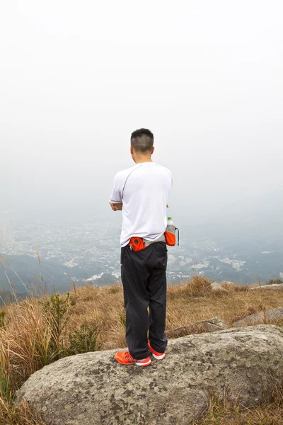 Asian man hiking in mountains — Stock Photo, Image