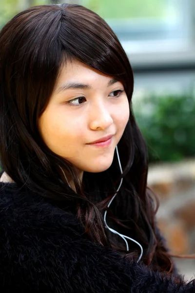 Asiatisk kvinna lyssnar musik — Stockfoto